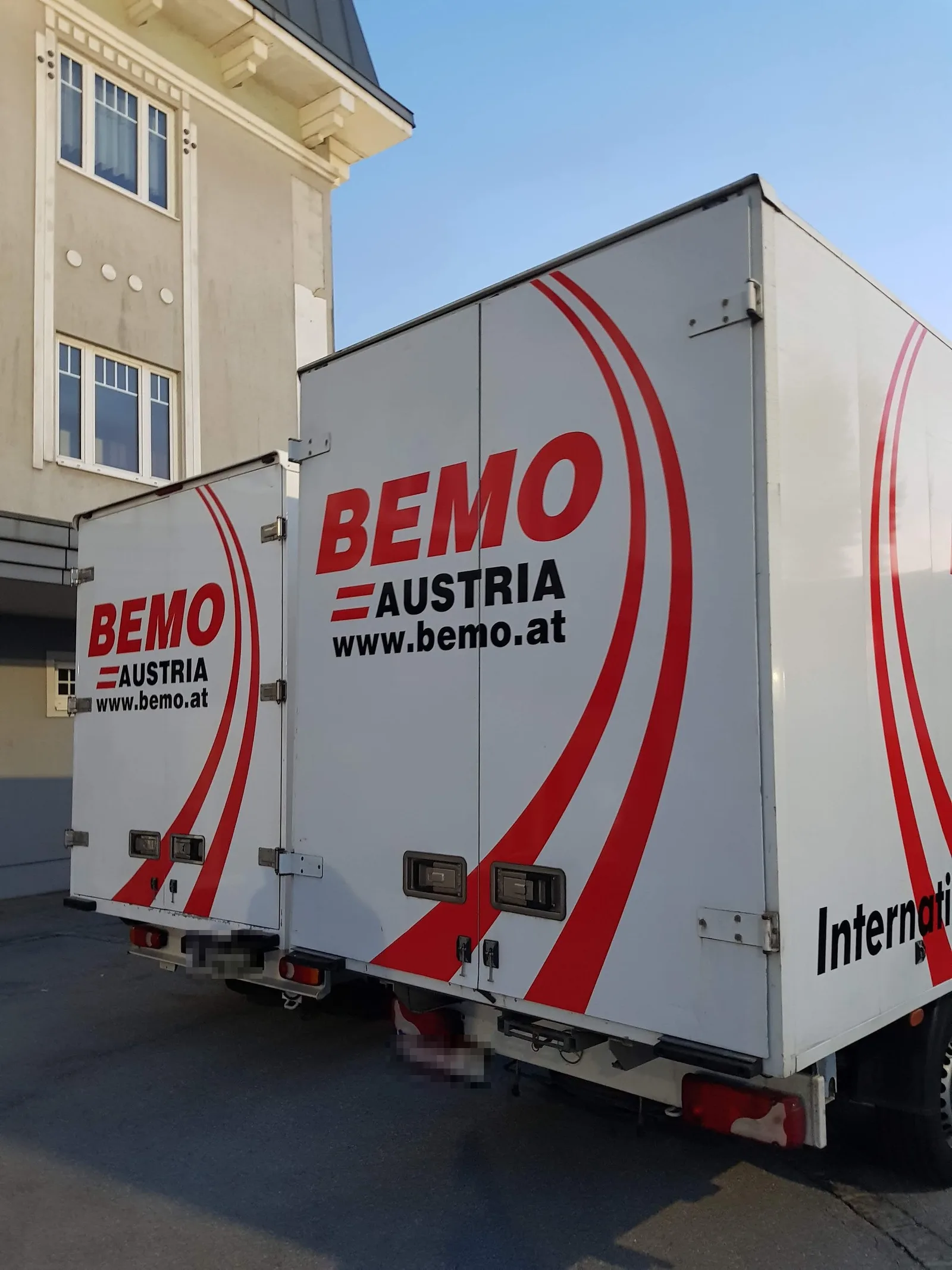 Zwei BEMO-Koffer-LKW von hinten vor einem Altbau