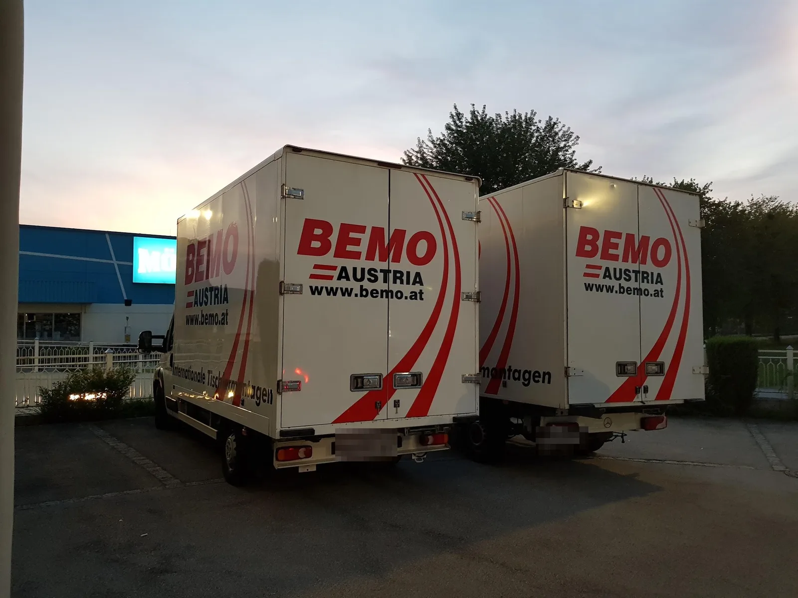 Zwei BEMO-Koffer-LKW am Abend auf einem Parkplatz, von hinten